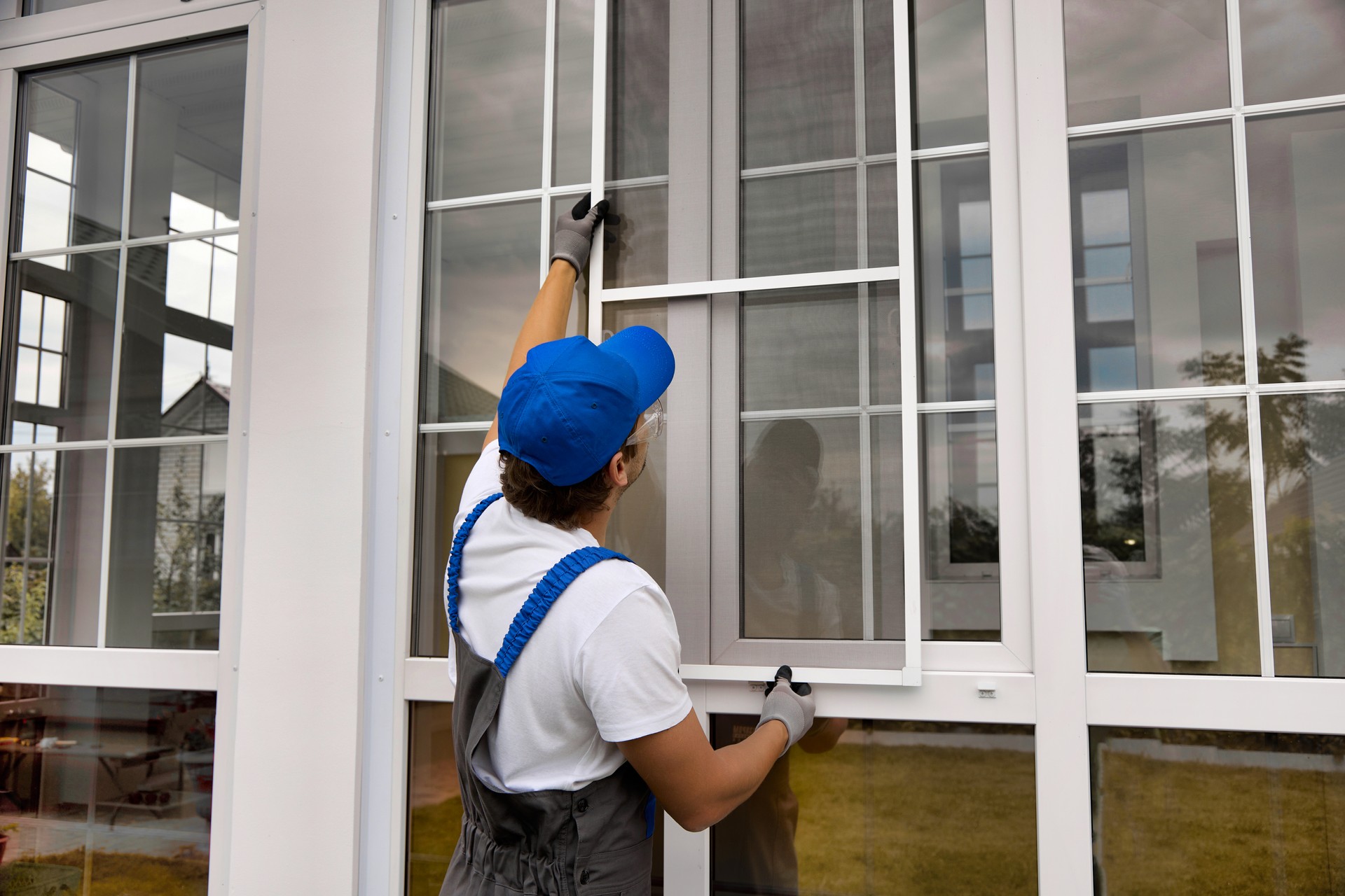 Installation of a mosquito net on a large window outside a modern building